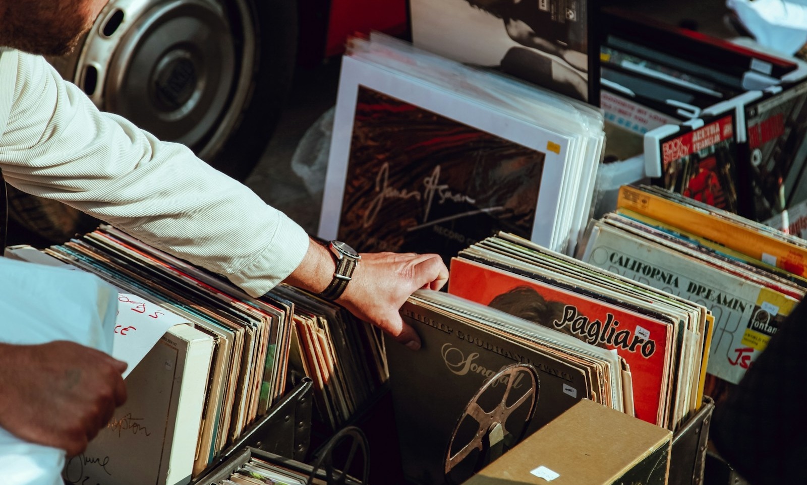 pessoa segurando discos de vinil