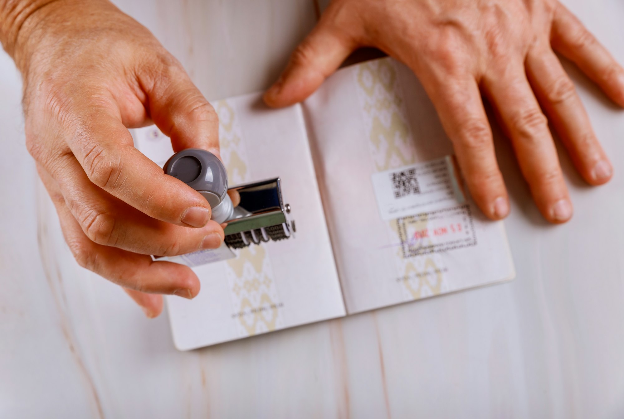 El oficial de control fronterizo pone un sello en la página del pasaporte de los sellos del pasaporte