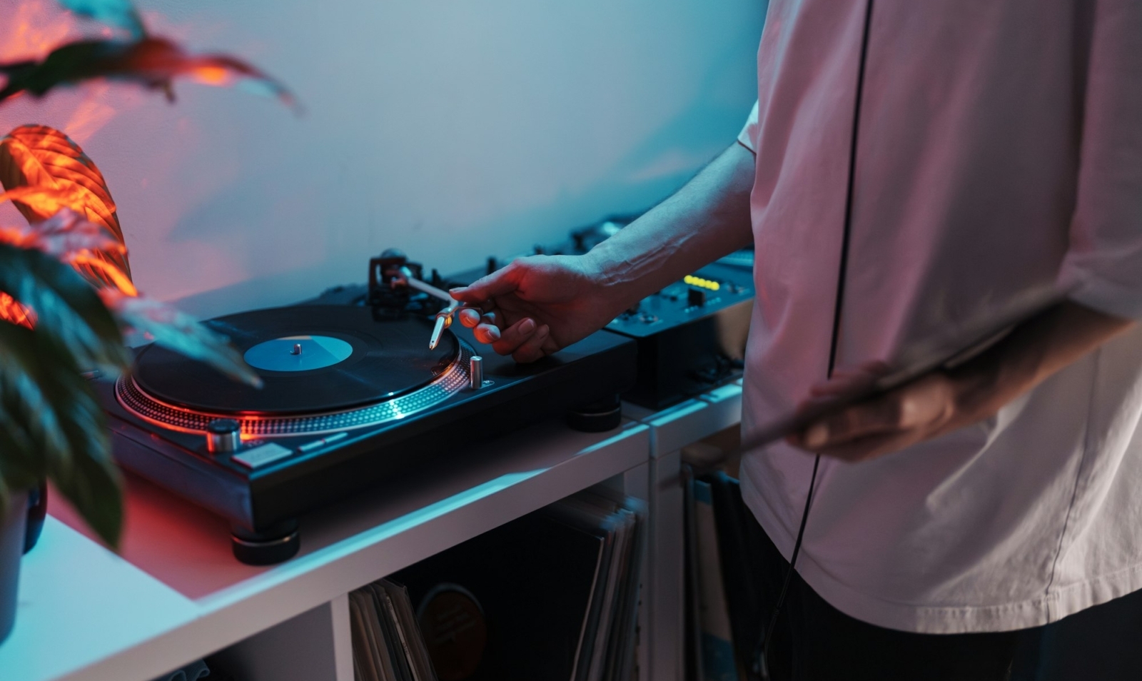 Dj mixing music on turntable in a home studio at night