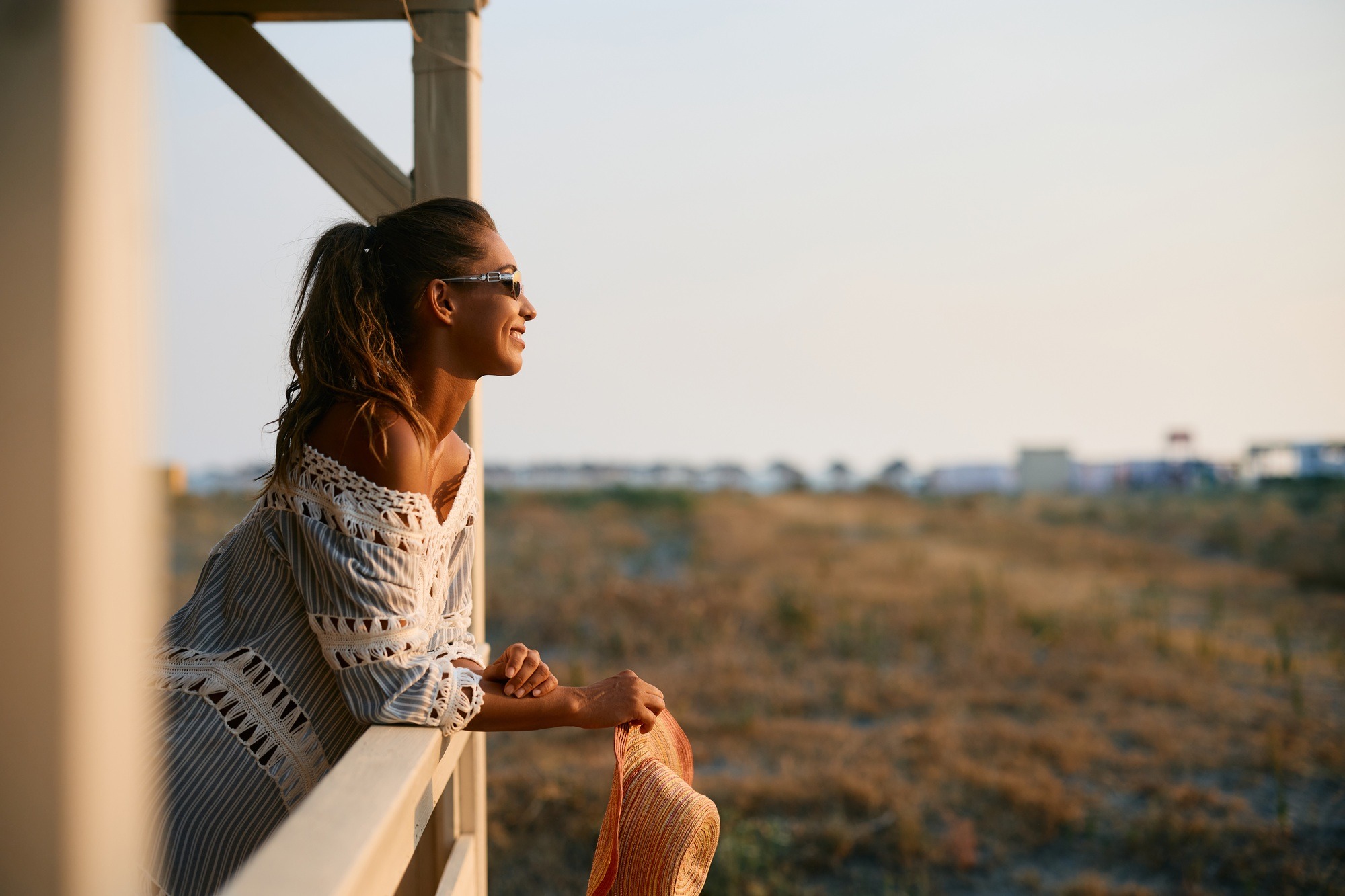 Carefree woman enjoying the view from a terrace of beach cabin.